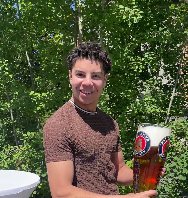 Lächelnd mit einem großen Bier in der Hand